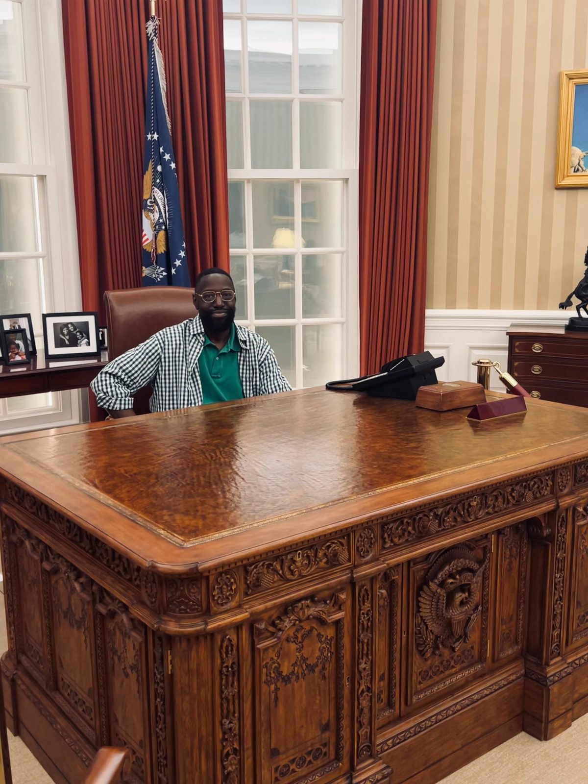 Bambo Adeshiyan at the replica Resolute desk in the Oval Office exhibit